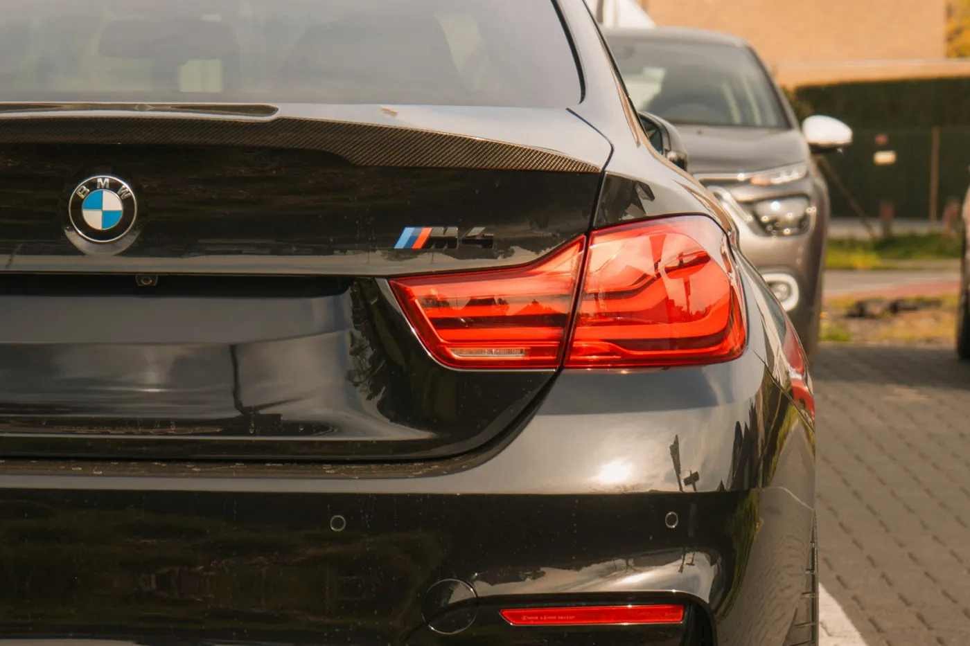 BMW M4 Competition negru, detaliu posterior cu stopuri LED și eleron carbon